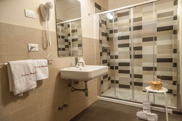 Bagno con lavandino, specchio e doccia