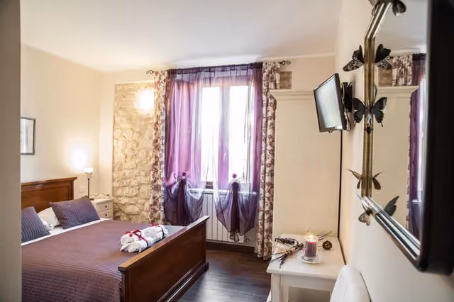 Camera della locanda con letti e finestra sul paese