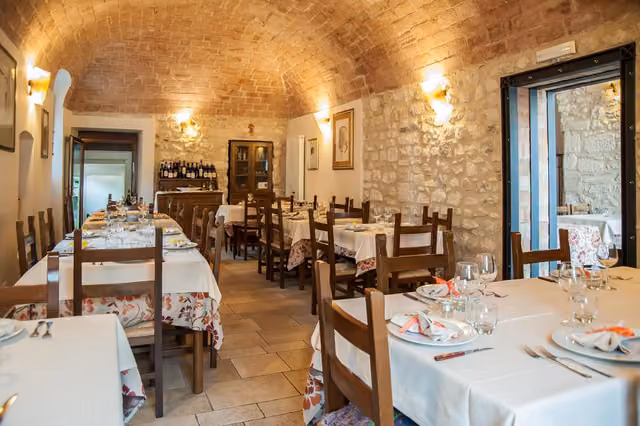 Tavoli e sedie con tovaglie bianche nella sala del ristorante a Poggio Picenze